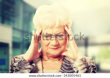 Old elegant lady is having a headache