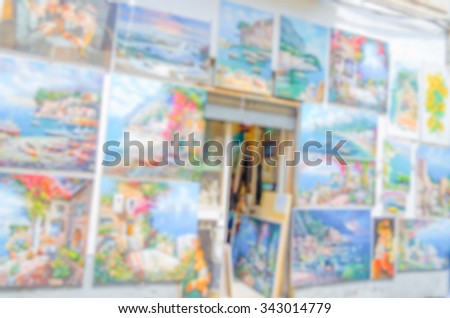 Defocused background with a wall full of paintings. Intentionally blurred post production for bokeh effect