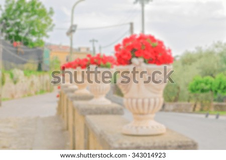 Defocused background with Ornate Vases of Red Flowers in Italy. Intentionally blurred post production for bokeh effect