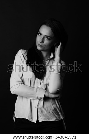Studio portrait of a young beautiful girl business student wearing shirt in black and white on black background