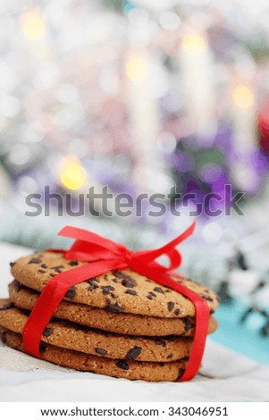 Chocolate cookies tied a red ribbon. Gift on a wooden background. Christmas background with copy space. Cooking cookies. 
