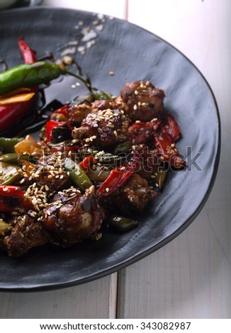 Chicken with vegetables and chili on a wooden background