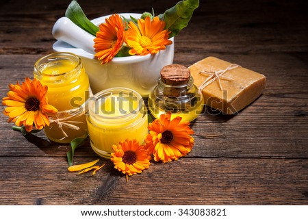 Homemade calendula ointment, soap and oil on wooden table