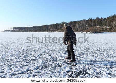 The man skating on the frozen river in the winter