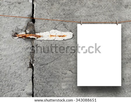 Vertical paper sheet frame hung by clothes pin on cracked stone wall background