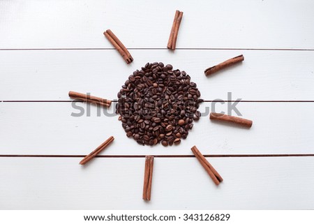 sun from coffee beans and cinnamon on a white wooden table
