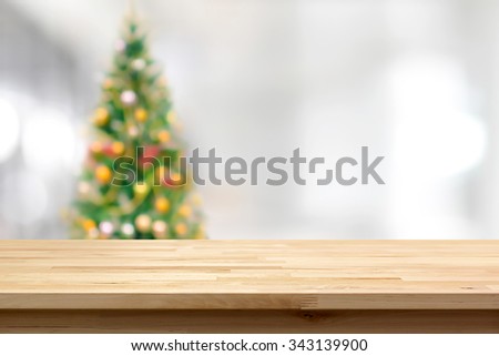 Wood table top on blur Christmas tree background - can be used for montage or display your products