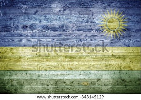 A vignetted background image of the flag of Rwanda onto wooden boards of a wall or floor.
