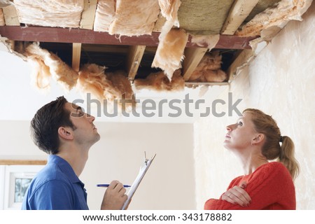 Builder And Client Inspecting Roof Damage Royalty-Free Stock Photo #343178882