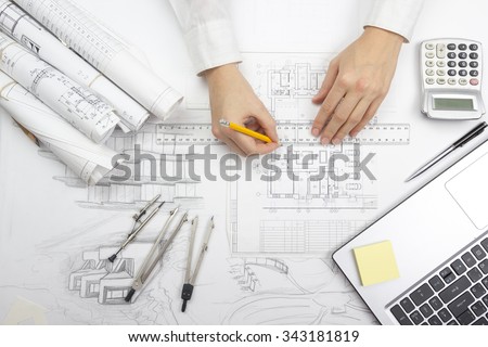Architect working on blueprint. Architects workplace - architectural project, blueprints, ruler, calculator, laptop and divider compass. Construction concept. Engineering tools. Top view Royalty-Free Stock Photo #343181819