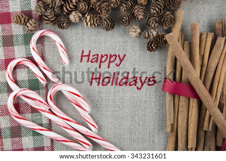 Linen fabric printed with Happy Holidays surrounded by cinnamon sticks, candy canes and pine cones.