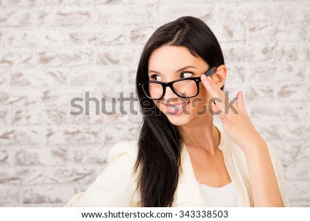 Elegant business woman adjusting her glasses and smiling