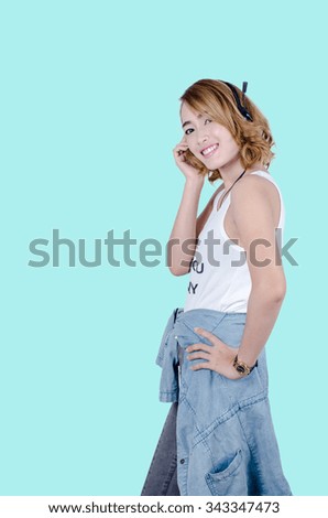 Happy Asian woman using headphone listening music,mp3 isolated on gray background