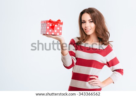 Portrait of a pretty smiling woman holding gift box isolated on a white background