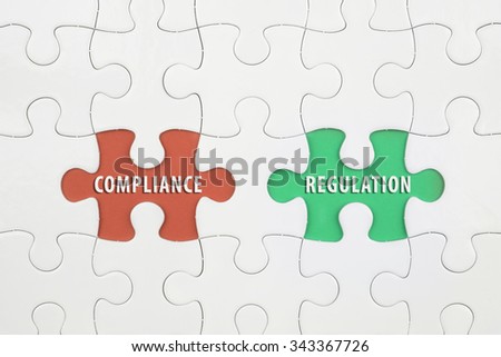 Jigsaw puzzle on color paper background with a word COMPLAINCE and REGULATION