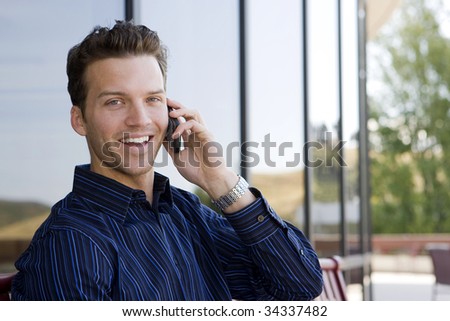 Attractive business man on his cell phone outside an office building