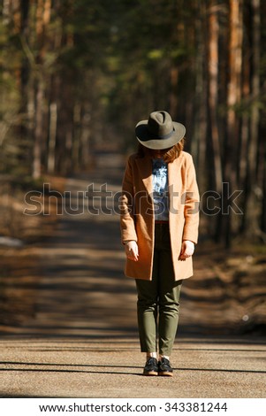 Girl in a forest grove standing with his head down