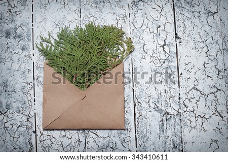christmas fir tree, envelope on wooden background.