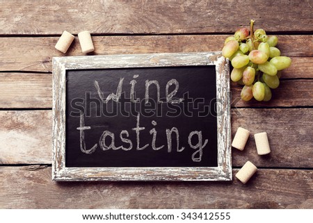 Old chalk scripted frame with grape on wooden background