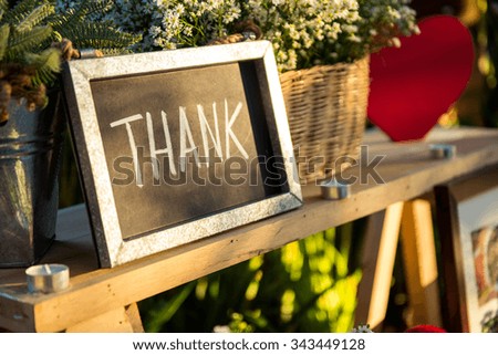 Thank you blackboard sign with red heart and basket of flowers