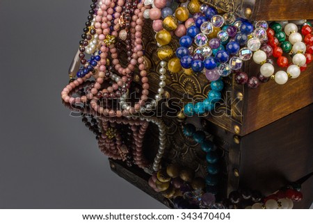 Jewelry box with natural semiprecious stones necklaces and bracelets on black background