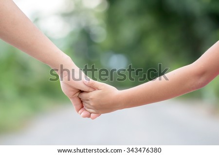 hand of parent and child on the background blurred nature.Mother holding hands baby Royalty-Free Stock Photo #343476380