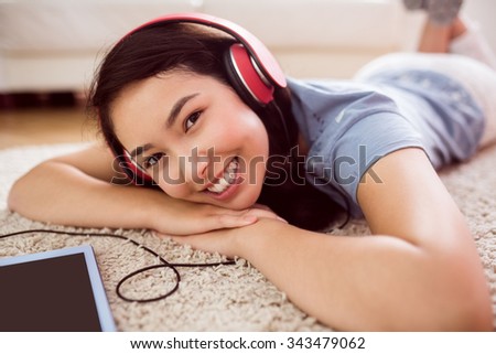 Asian woman using tablet on floor at home in the living room