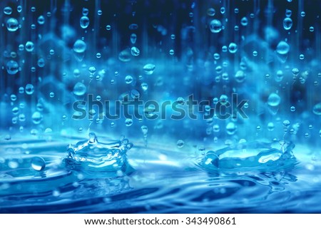 The blue color tone of close up rain water drop falling to the floor in rainy season 