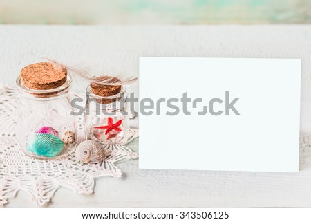 Vintage toned marine inspired mockup on a wooden background. Mason jars and sea shells on a lacy napkin. 