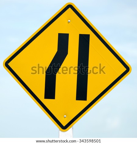 Road narrows traffic sign and blue sky 