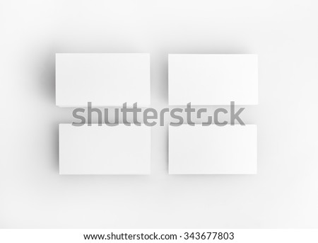 Photo of blank business cards with soft shadows on light wooden background. For design presentations and portfolios.