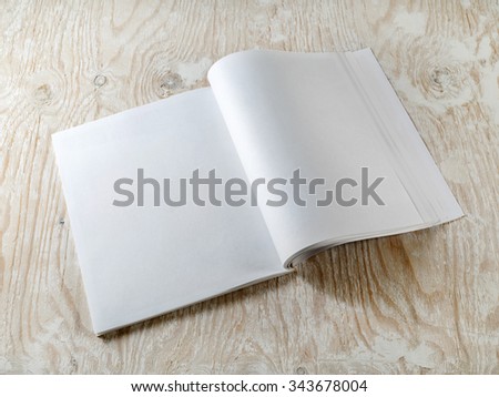Blank booklet on wooden textural background with soft shadows. Mock-up for graphic designers portfolios.