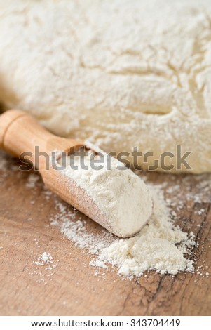 scoop of wheat flour and freshly prepared dough