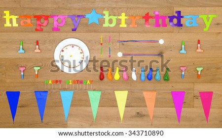 happy birthday themed background image, with an array of items and objects on a wooden surface, including candles, cake, balloons, garlands and party gifts