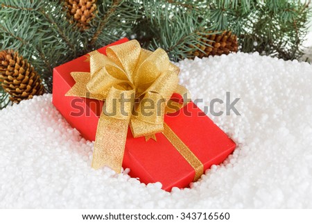 Christmas Gift box with ribbon in snow  under pine tree. Concept for , New Year holidays