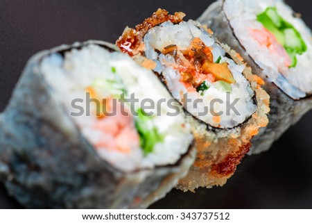 Macro of three different sushi on black background