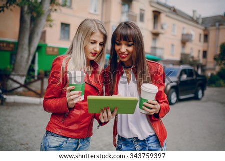 two beautiful girls photographed with gadgets and walk city
