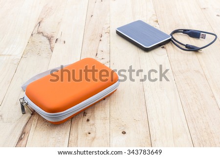 External hard drive carrying case. Bags for external hard drive on wood background.