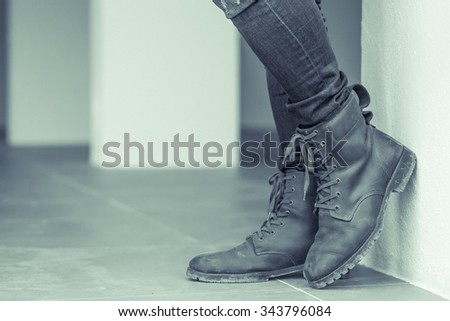 male with fashion brown leather boots aligned selective focus, add little noise and make green tone.