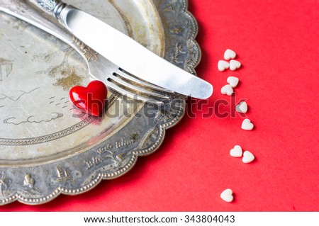 Valentines table setting with vintage silverware and red heart as a decoration