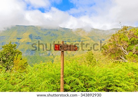 Signpost showing the way to 25 Fontes and Risco, famous walk trail for hikers on Madeira with the magnificent inland of the island of Madeira in the background