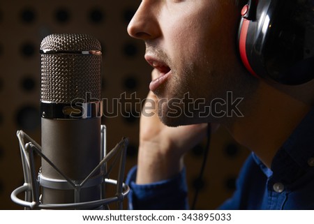 Male Vocalist Singing Into Microphone In Recording Studio Royalty-Free Stock Photo #343895033