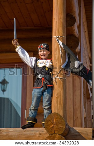 The boy in a costume of the pirate swings a sabre