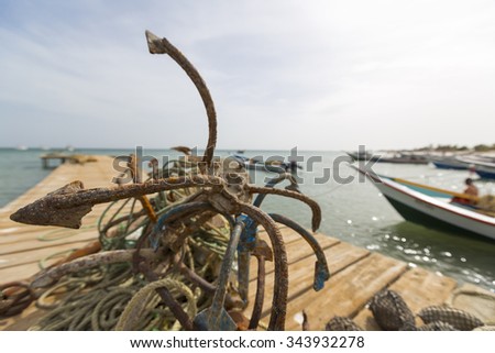 Details of a fishing boat anchor in the harbor of Boca de Pozo with the ocean and a clear blue sky in the background. Margarita Island. Venezuela 2015 (Selective focus)