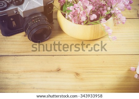 Office desk table with camera, supplies and flower. Top view with copy space