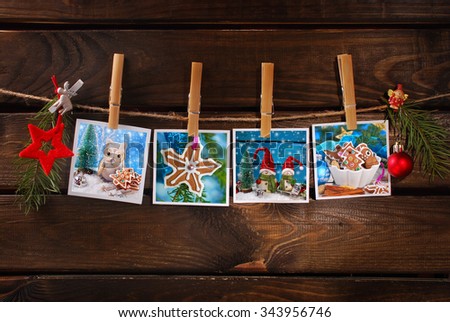 four beautiful christmas cards hanging on rope  against old wooden background