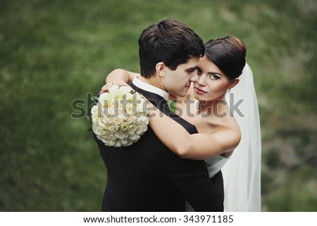elegant stylish young couple beautiful bride and groom embracing