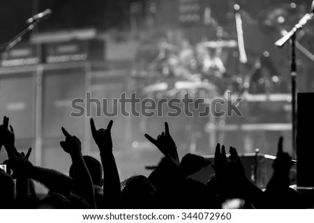 Bunch of fans happy during a concert throwing up the devil horns