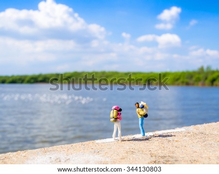 two plastic toys with back pack standing in front of the sea