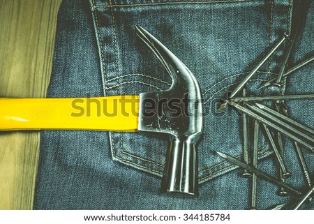 A hammer and nails on jeans